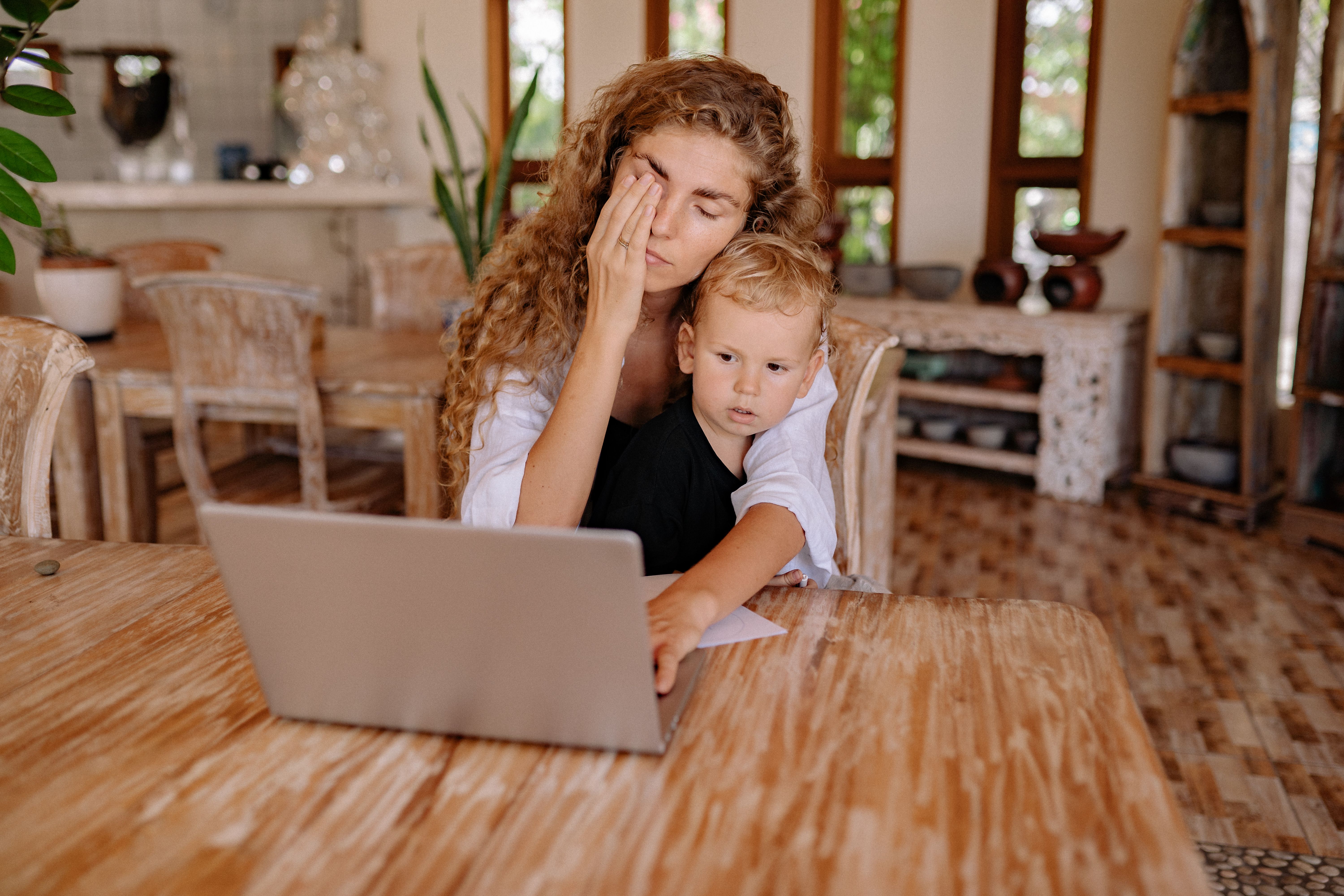 Mother sitting thoughtfully with her young child while navigating emotional triggers and past trauma in motherhood.